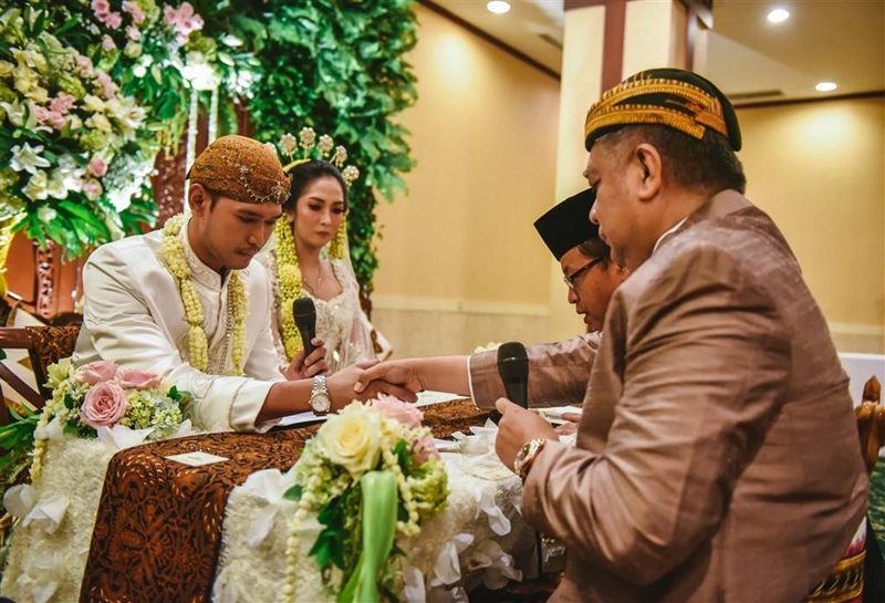 Adit menjabat tangan penghulu yang sering membuat gugup setiap pengantin pria